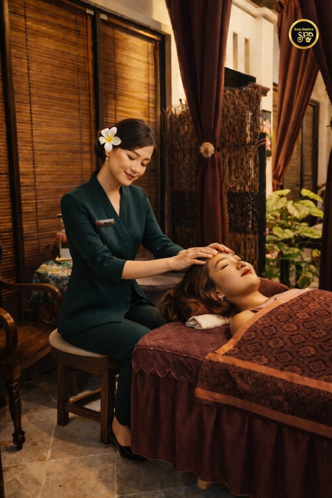 Spa therapist performing relaxing head massage treatment at Yoyoy Kamphora Spa
