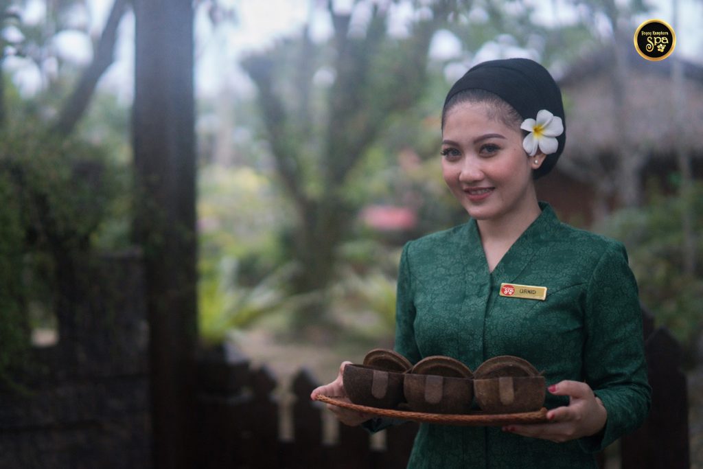Spa therapist holding traditional bowl at Yoyoy Kamphora Spa Cherating
