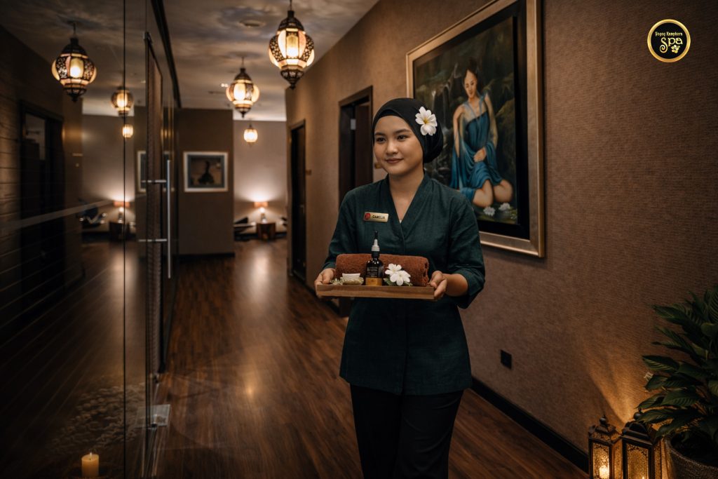 Spa therapist walking through ambient corridor carrying treatment tray at Yoyoy Kamphora Spa
